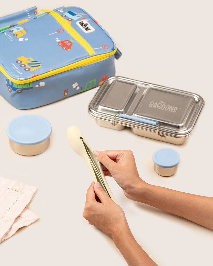 Mom packing Baboons stainless steel cutlery into reusable lemon sorbet yellow silicone case with kids school tiffin India. Perfect for corporate meal, University and travel friendly without plastic waste.
