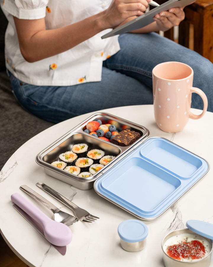 Mom enjoying corporate work lunch with reusable stainless steel cutlery set in lilac silicone case by Baboons India.