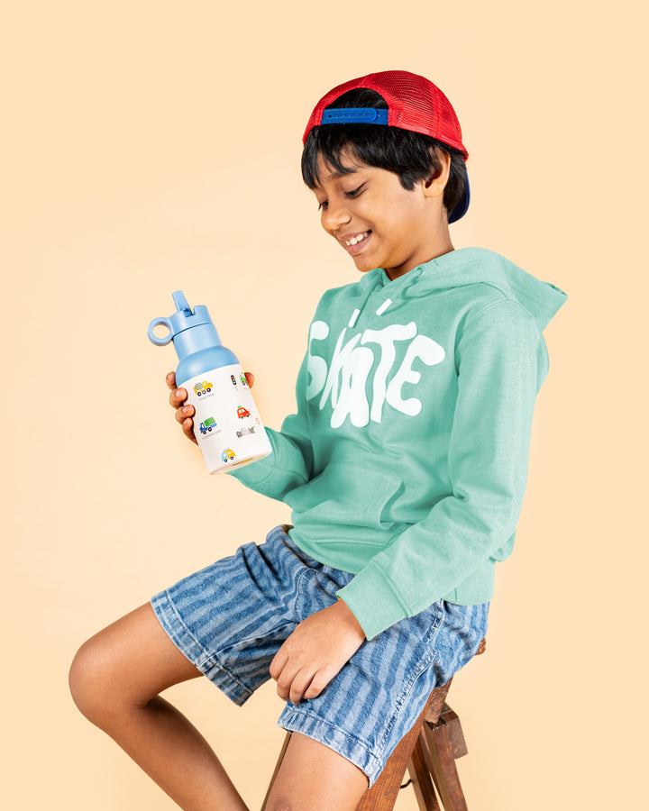 Indian boy holding Baboons 350ml blue vehicles water bottle with sipper lid, ideal for kids school hydration and travel