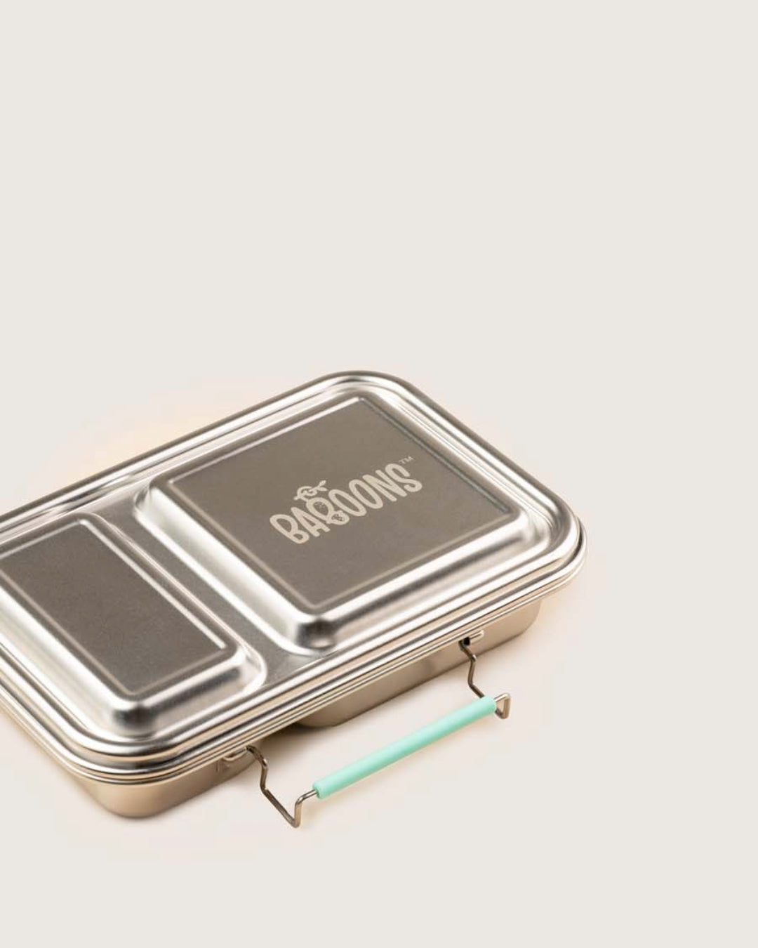 Metal lunch box with 'Baboons' branding on a light background