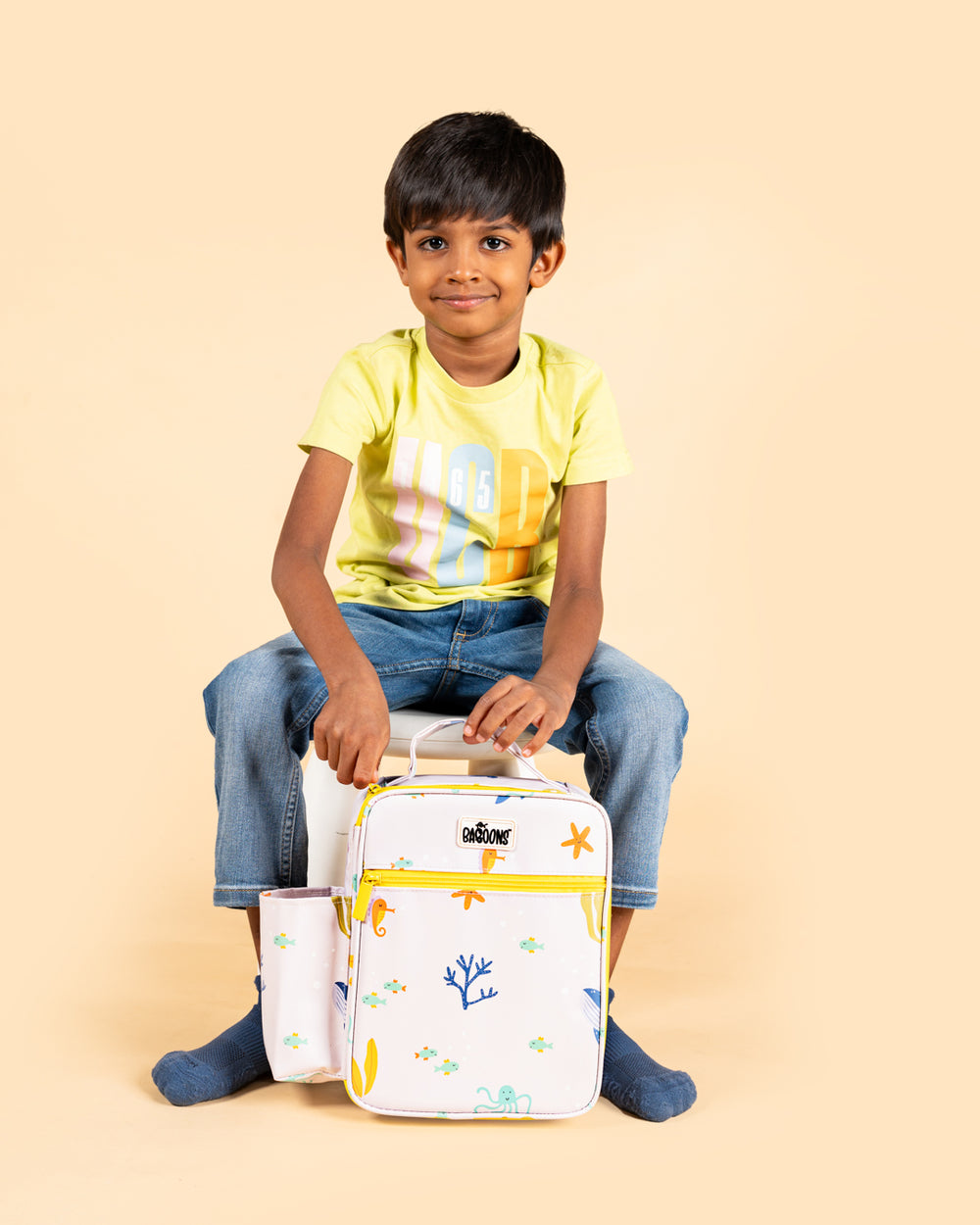 Smiling boy holding Baboons insulated kids lunch bag - underwater design, durable, water-resistant, perfect for bento boxes and snacks, available in India