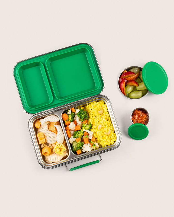 Leakproof green stainless steel lunchbox in India with two compartments, featuring lemon rice with steamed veggies and fryums, ideal for kids and adults, eco-friendly and durable, with an additional snack container of fruits and pickle.